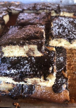 Una foto de Cuadraditos de vainilla, con trozos de manzana, pasas de uva, bañada con chocolate