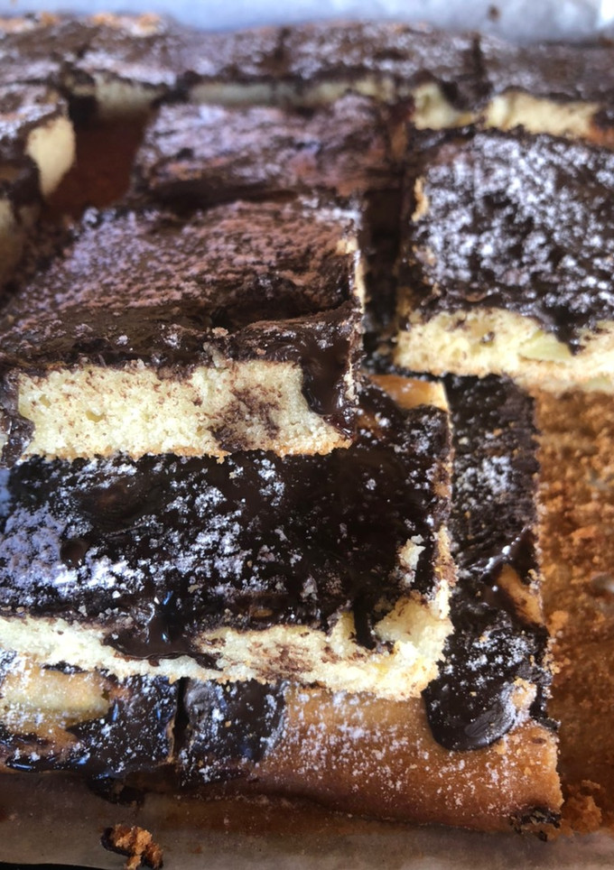 Una foto de Cuadraditos de vainilla, con trozos de manzana, pasas de uva, bañada con chocolate