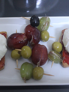 Una foto de Huevos poche sobre tostadas con uvas rellenas de anchoa
