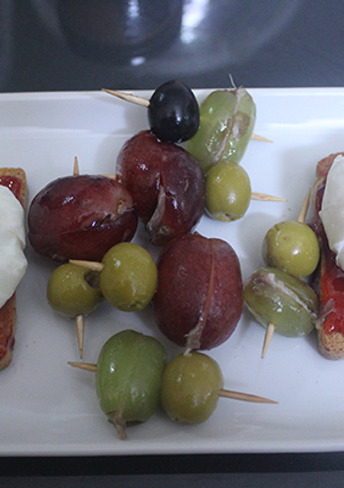 Una foto de Huevos poche sobre tostadas con uvas rellenas de anchoa