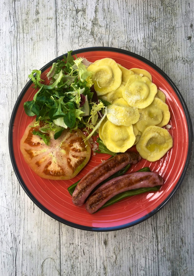 Una foto de Salchichas con pimientos en Lékué Grill acompañadas de raviolis y ensalada
