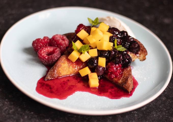 French toast with raspberry and blueberry compote and fresh mango