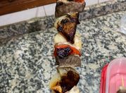 Una foto de brochetas de carne y pollo