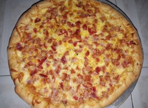 Una foto de Pizza de salchicha, salami y jamón con borde de queso