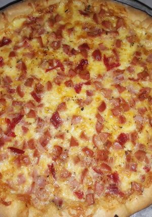 Una foto de Pizza de salchicha, salami y jamón con borde de queso