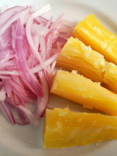 Una foto de Yuca sancochada con salsa de cebolla