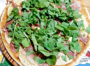 Una foto de Pizza de provoleta, jamón crudo y rúcula