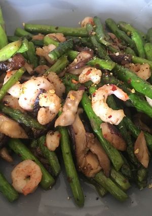 A picture of Asparagus with prawns and mushrooms.