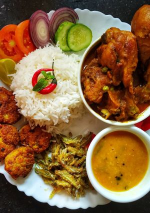 মধ্যাহ্নভোজনের থালি। (টমেটো দিয়ে মুসুরির ডাল, পোস্তর বড়া,মৌরালা মাছ ভাজা, দই চিকেন ও স্যালাড) রেসিপির প্রধান ছবি