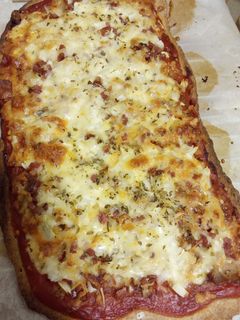 Una foto de Pizza de kebab con jamón Serrano, cebolla y salsa de yogurt