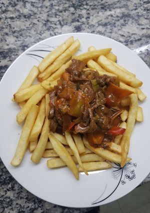 Una foto de Chop suey de pollo y carne con fritas