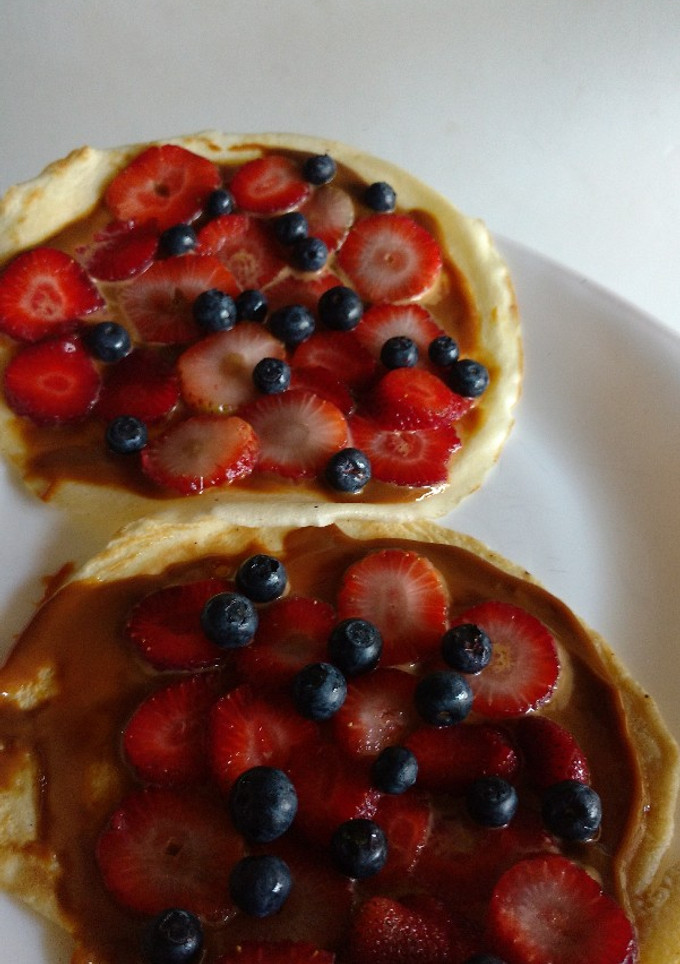 Una foto de Panqueques simple con dulce de leche, frutilla y moras