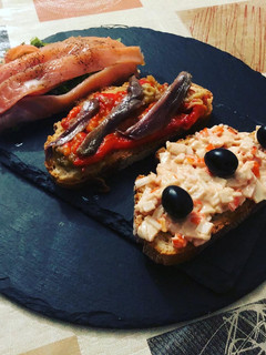 Una foto de Rebanadas variadas de salmón, sucedáneo de cangrejo, escalivada y anchoas