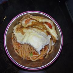 A picture of Spaghetti jellof with fried egg.