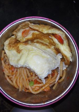 A picture of Spaghetti jellof with fried egg.