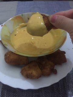 Una foto de Pollo frito con salsa cheddar 🍗 🧀