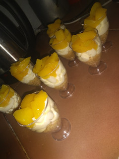 Una foto de Postre de durazno con crema en copitas