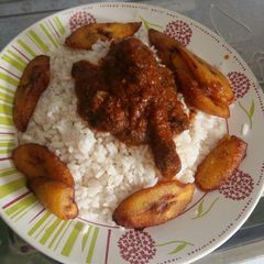 A picture of White Rice, chicken stew and plantain.