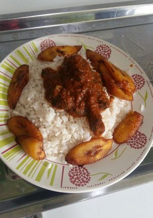 A picture of White Rice, chicken stew and plantain.