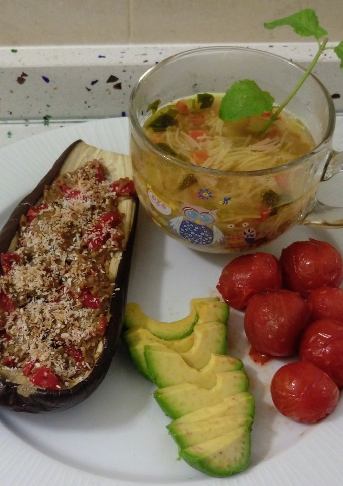 Una foto de Berenjenas rellenas gratinadas con coco, tomates cherrys asados y sopa