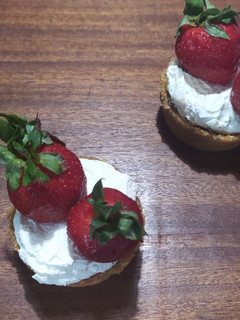 A picture of Mini Tarts with Ganache, Whipped Cream, and Strawberries.
