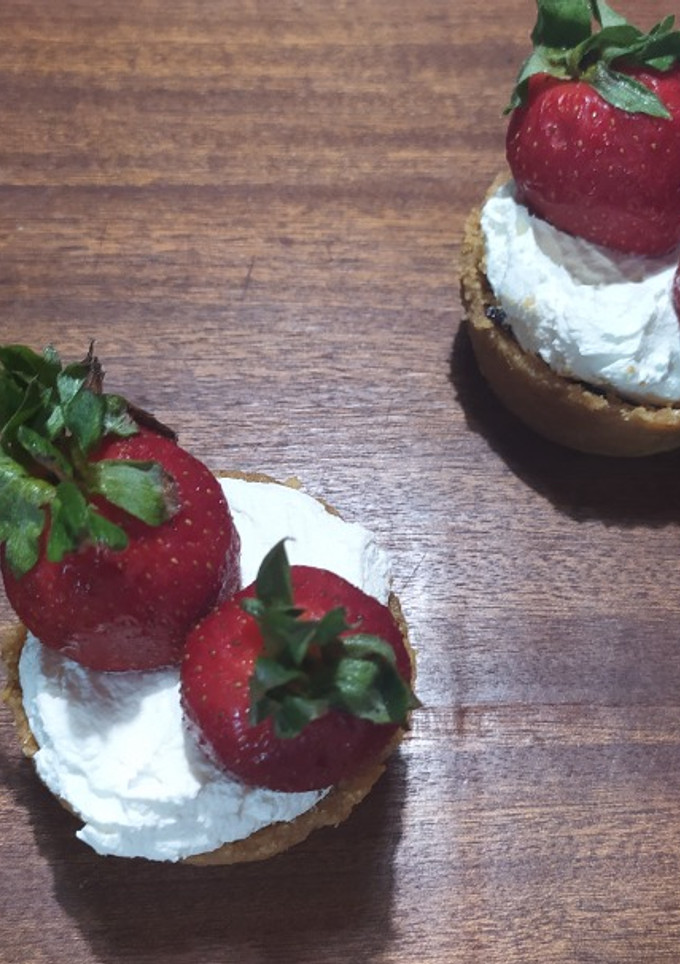 A picture of Mini Tarts with Ganache, Whipped Cream, and Strawberries.