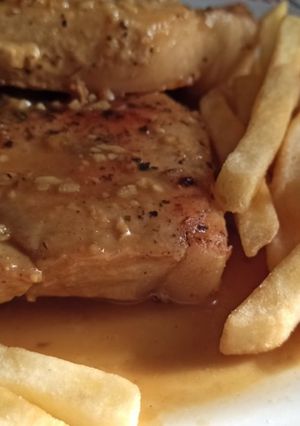 Una foto de Costeleta de Cerdo con Papas Fritas rebozadas en un jarabe de Mostaza a la miel con vino