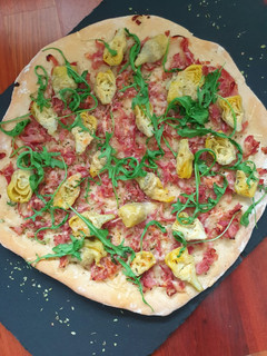 Una foto de Pizza de alcachofas, jamón y rúcula