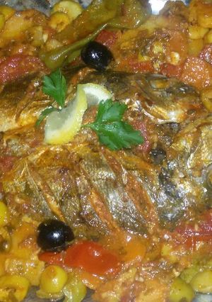 Une photo de Tadjine de poisson au four avec quartier de tomate
