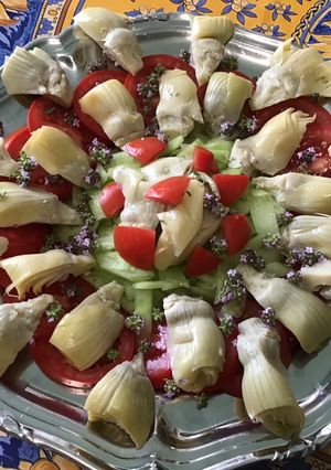 Une photo de Salade de coeurs d'artichauts aux tomates, concombre et fleurs de thym