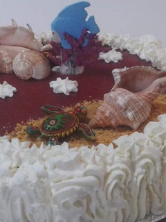 Una foto de Tarta de queso mascarpone y nata con Mar Rojo y arena de galletas