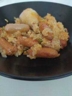 Una foto de Arroz con pollo y salchichas blancas y rojas