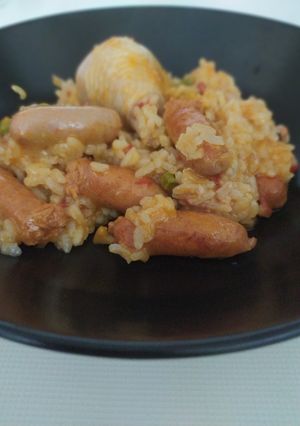 Una foto de Arroz con pollo y salchichas blancas y rojas