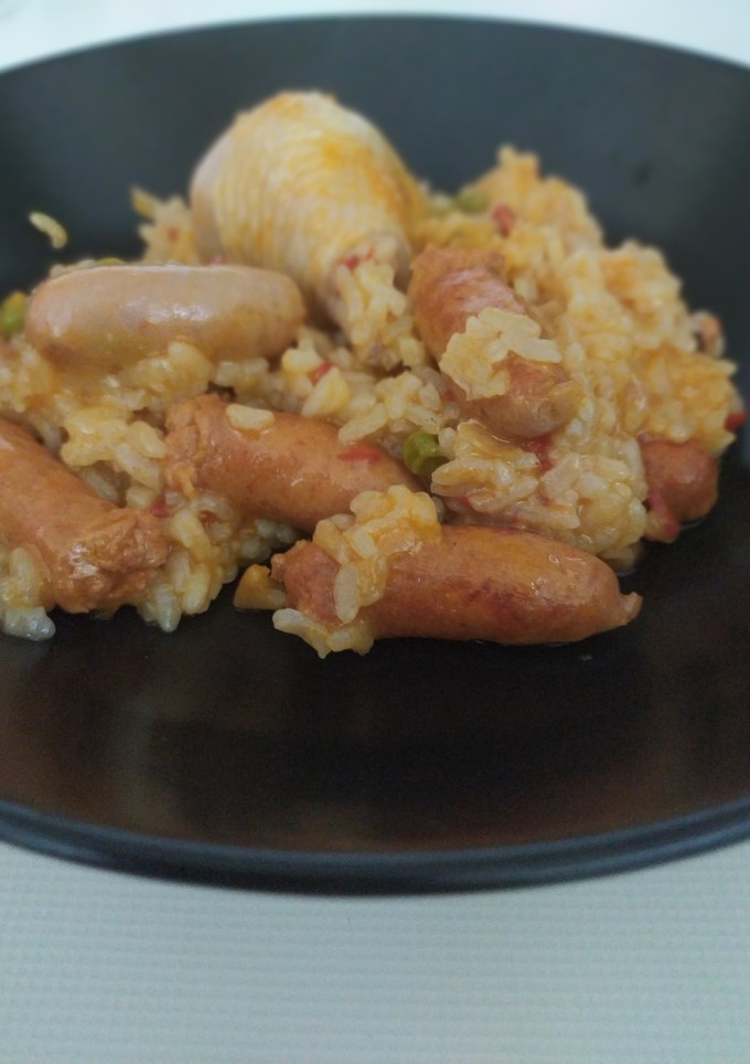 Una foto de Arroz con pollo y salchichas blancas y rojas