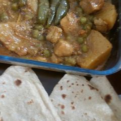 A picture of Chicken Aaloo mater with roti.