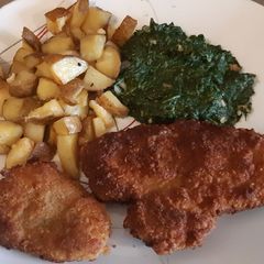 A picture of Schnitzel with oven roasted potatoes.