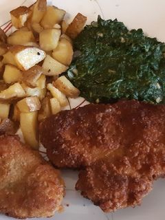 A picture of Schnitzel with oven roasted potatoes.