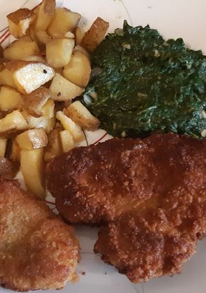 A picture of Schnitzel with oven roasted potatoes.