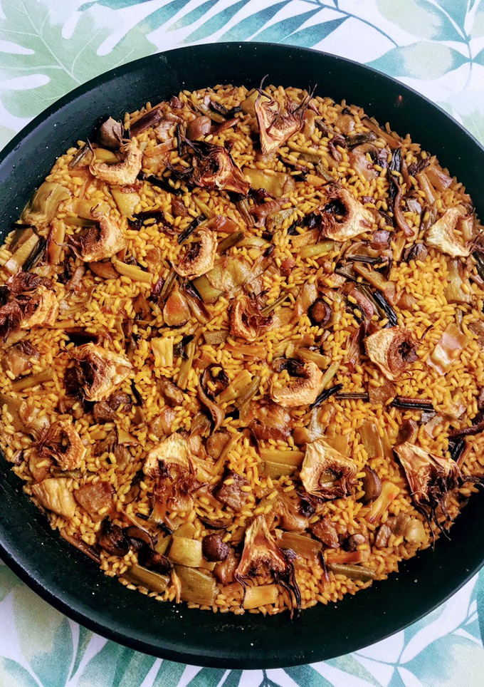 Una foto de Paella 🥘 de secreto ibérico, ajos tiernos y alcachofas