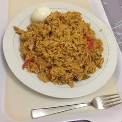 A picture of Jollof rice with shredded chicken.