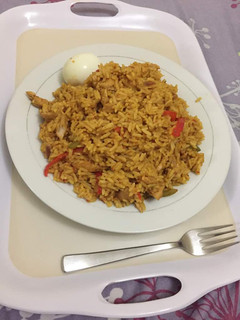A picture of Jollof rice with shredded chicken.