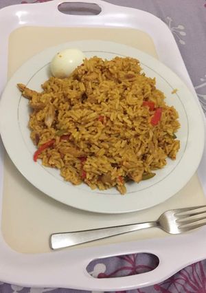 A picture of Jollof rice with shredded chicken.