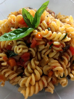 Una foto de Fideos espirales con tomate, albahaca y aceitunas