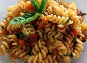 Una foto de Fideos espirales con tomate, albahaca y aceitunas