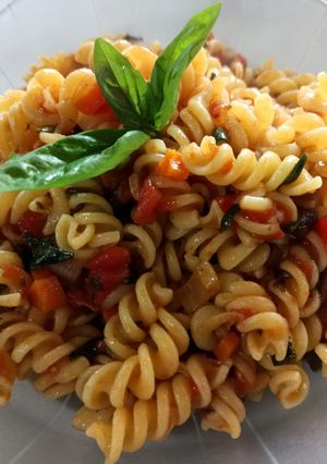 Una foto de Fideos espirales con tomate, albahaca y aceitunas