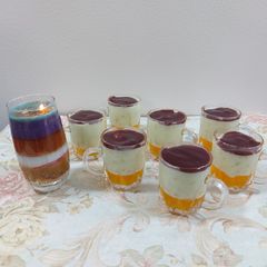 A picture of Fruit custard with orange jelly and strawberry palm sauce.