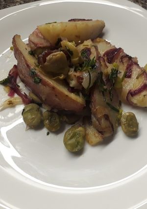 Una foto de Papas salteadas en gajos con habas