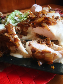 Una foto de Pechuga de pollo con rulo de cabra y cebolla caramelizada