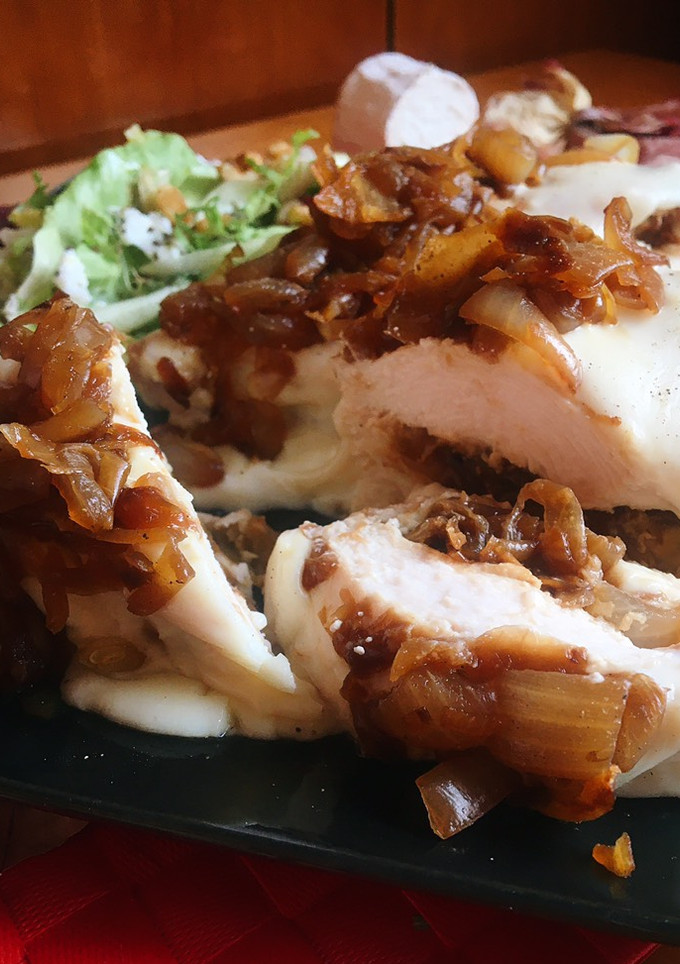 Una foto de Pechuga de pollo con rulo de cabra y cebolla caramelizada