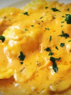 Una foto de Raviolis de queso con salsa Romesco